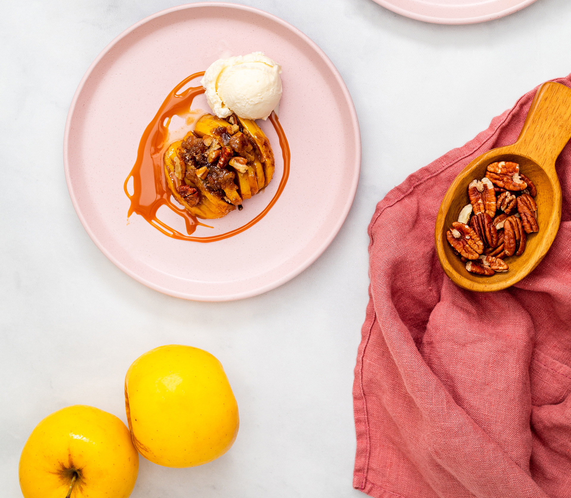 Image of an apple, cut up and baked, tops with vanilla ice cream 